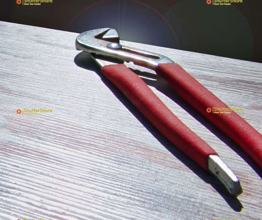 Close-Up of Red Handled Pliers on Wooden Surface