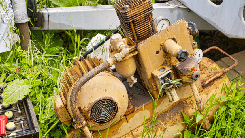 Rusty Industrial Machinery in Overgrown Grass