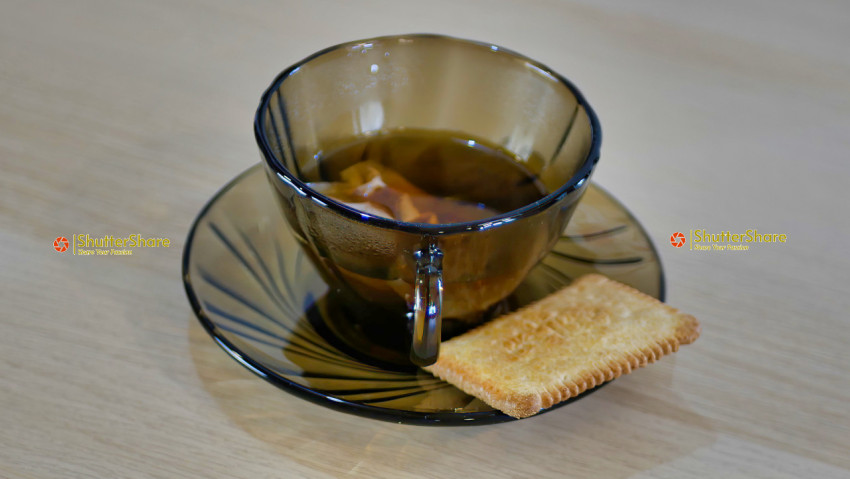 Close-Up of Tea in Amber Cup with Biscuit