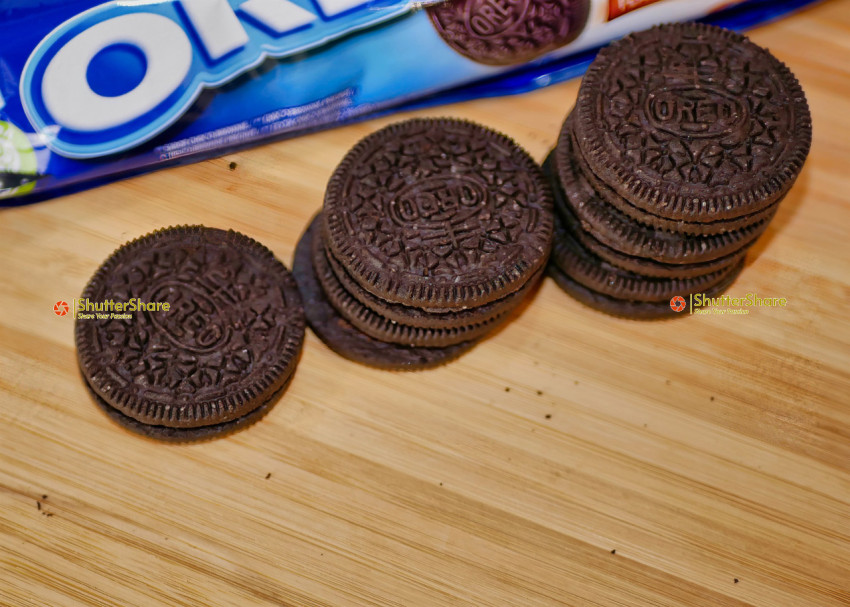 Stacked Oreo Cookies with Packaging on Wooden Surface