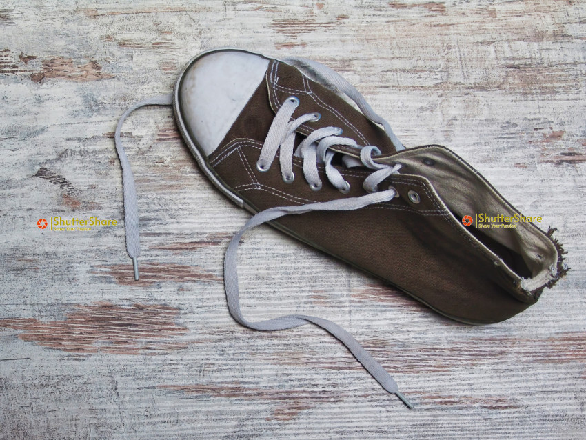 Worn-Out Sneaker on Distressed Wooden Surface