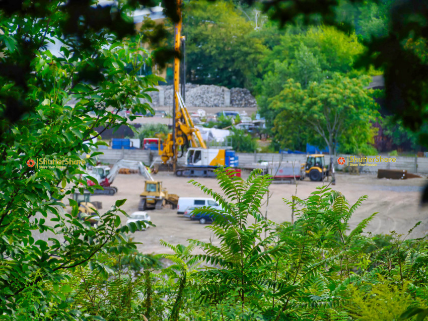 Construction Site Glimpsed Through Foliage