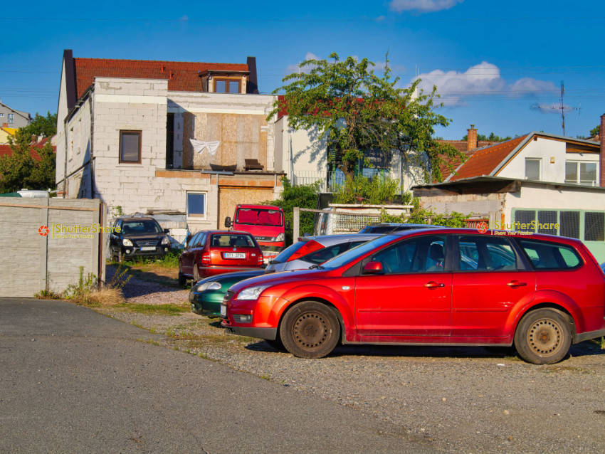 Red Car in a Crowded Backyard
